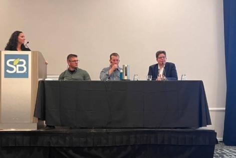 Panel of four speakers on stage discussing sustainability.