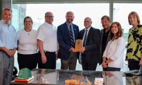 Group of people stand together as one holds an FSC award plaque.