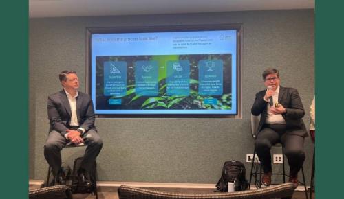 Two speakers talk beside a slide outlining FSC’s process for forest management.