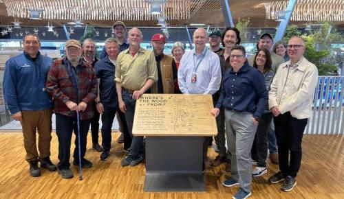 The group gathers around a wooden display titled “Where’s the Wood From?” inside a timber-framed building.