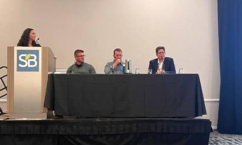 Panel of four speakers on stage discussing sustainability.